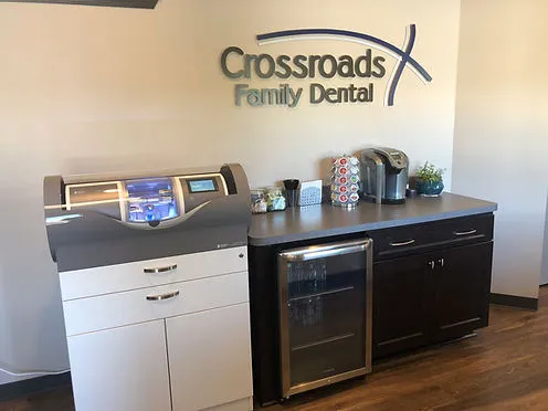 The CEREC milling unit in the Crossroads Family Dental reception area, visible to patients through the viewing window